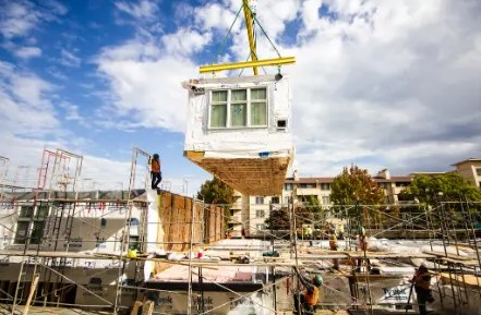 Module being lowered by crane onto a podium